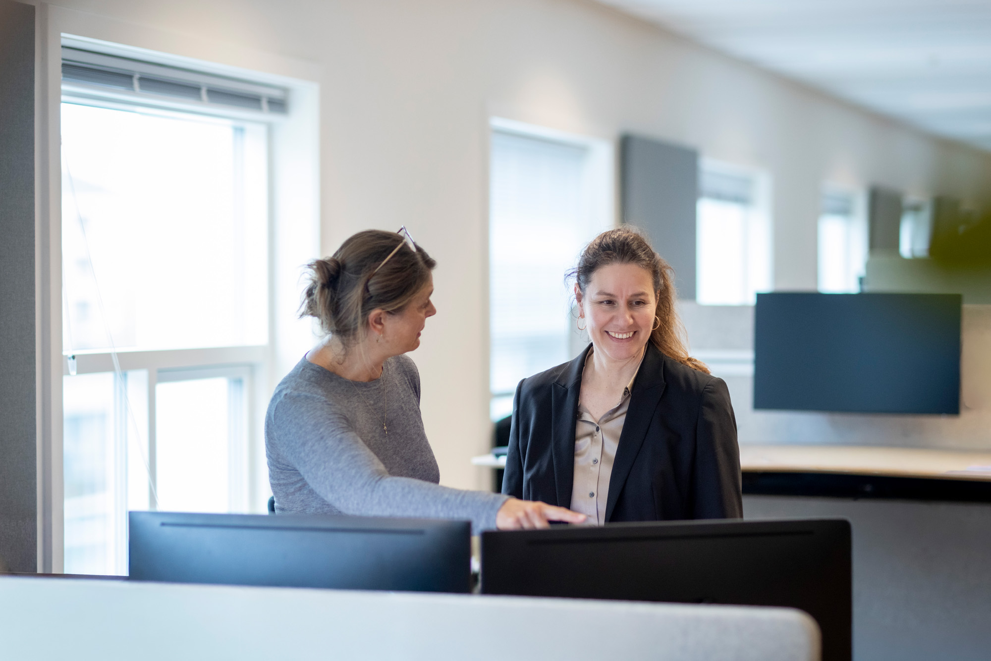 Billede af 2 medarbejdere ved skærme